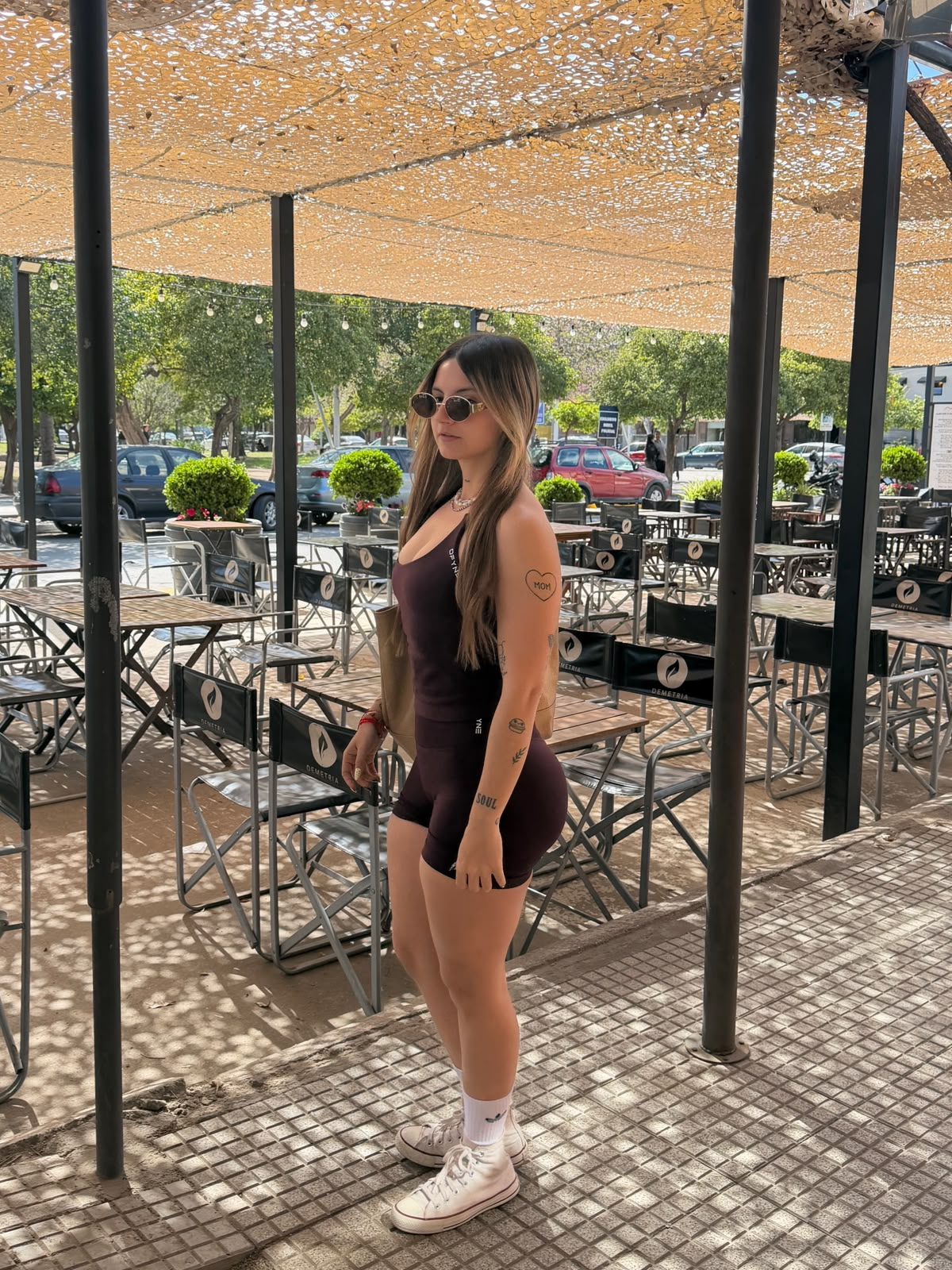 Mujer con conjunto deportivo ISLA en un café al aire libre